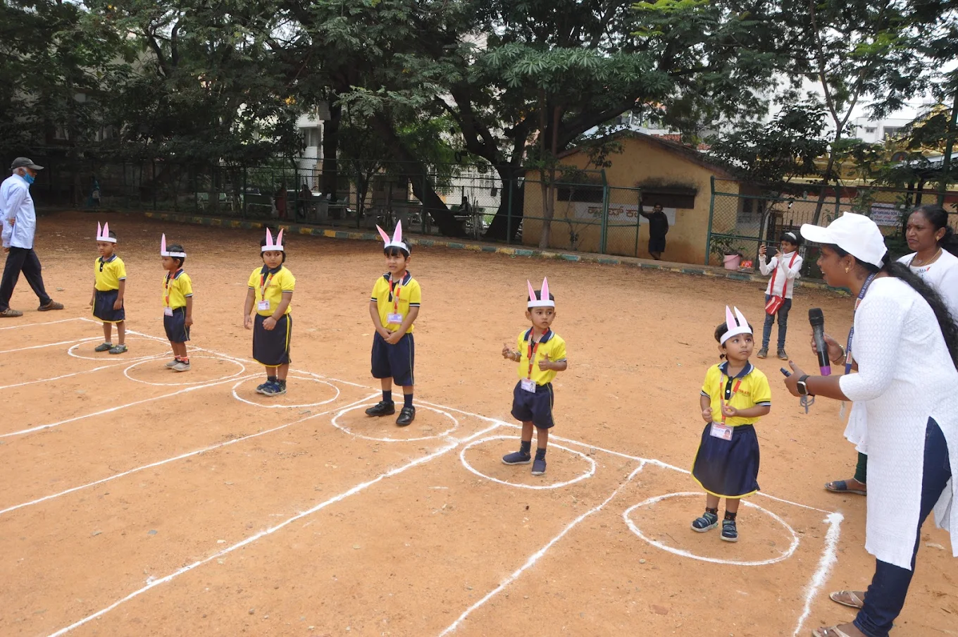 Preschool children participating in outdoor track and bunny hop games on sports ground